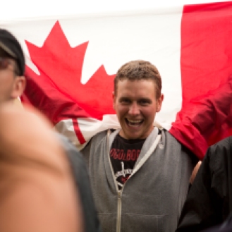 A fan holds up a Canada flag at the Elliott Brood show Monday afternoon. Photo by Kim Jay.